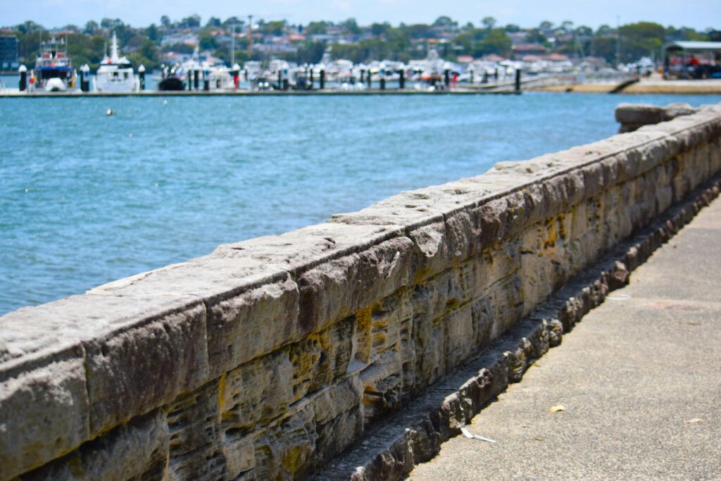 a stone wall next to a body of water