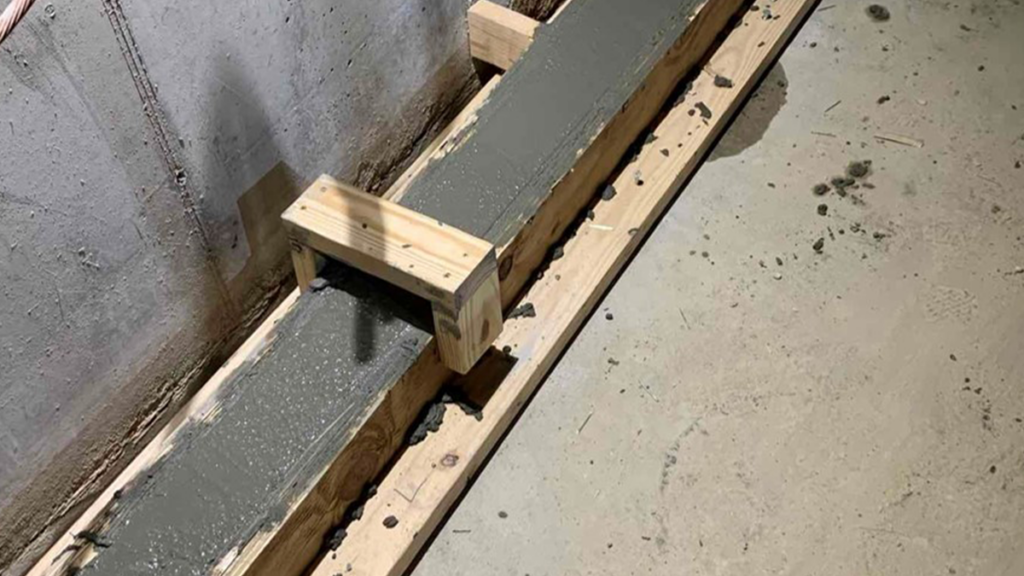 Installed concrete curb, sump pump to create perimeter trench